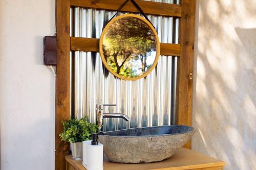 a bathroom with a stone sink and a mirror at Kampaoh Somo Parque in Somo