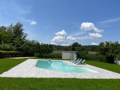 una piscina con 2 tumbonas en el césped en Magnifique villa contemporaine 8 personnes en Pierrevert