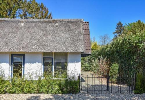 an old white house with a thatched roof at Cosy forest hideout @ Veluwe in Putten
