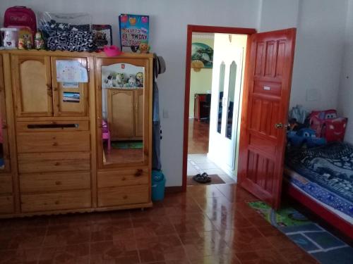 Otavalo Ecuador (casa familiar) في اوتابالو: غرفة مع خزانة وغرفة نوم