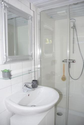 a white bathroom with a sink and a shower at Cosy forest hideout @ Veluwe in Putten