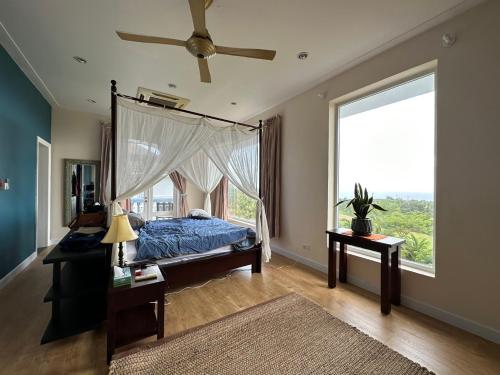 a bedroom with a canopy bed and a large window at Villa Sealinks City Mui Ne 3br - SeaHome O867,7O7,123 in Phan Thiet