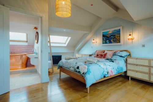 a bedroom with a bed and a sink and a tub at Luxury sea-view apartment in Tenby - Floral Corner in Pembrokeshire