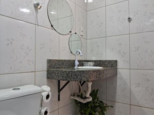 a bathroom with a sink and a mirror and a toilet at Pousada Jardim da Lagoa-BA in Bom Jesus da Lapa