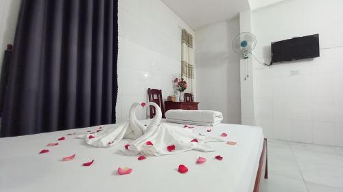 a white bed with red rose petals on it at THAI BINH MOTEL in Danang