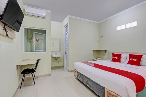 - une chambre avec un lit, un bureau et une télévision dans l'établissement OYO 92642 Tumesa Homestay 2 Syariah, à Semarang