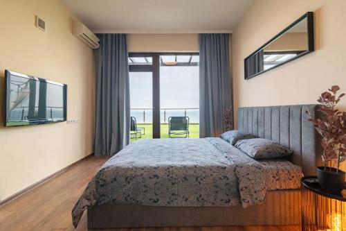 ein Schlafzimmer mit einem Bett und einem großen Fenster in der Unterkunft MareliS Skies VIP Apartment in Topola