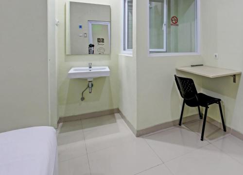 La salle de bains est pourvue d'un lavabo et d'une chaise. dans l'établissement OYO 92642 Tumesa Homestay 2 Syariah, à Semarang