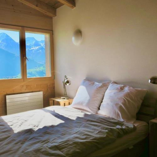 una camera con letto e vista sulle montagne di Casa Segnas a Disentis