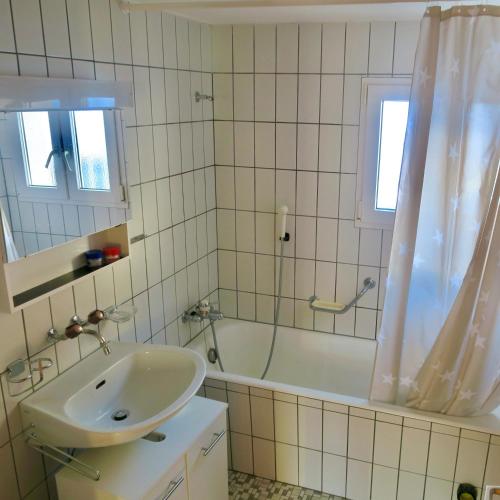 a bathroom with a sink and a tub and a shower at Casa Segnas in Disentis