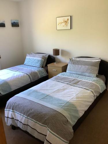 two beds sitting next to each other in a bedroom at Hillside in Dunvegan