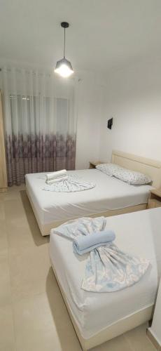 three beds sitting in a room with a light at Nika Apartments in Ulcinj