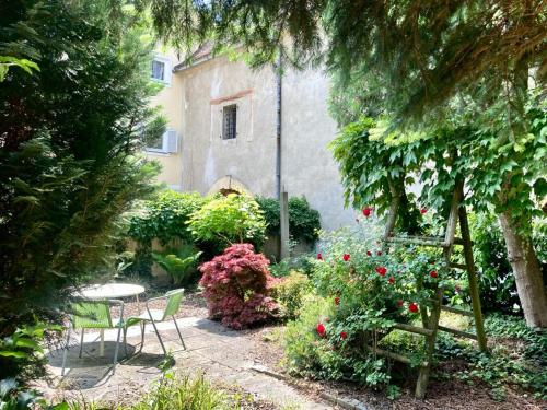 a garden with a table and chairs and flowers at Ferienwohnung am Tabor in Bad Radkersburg