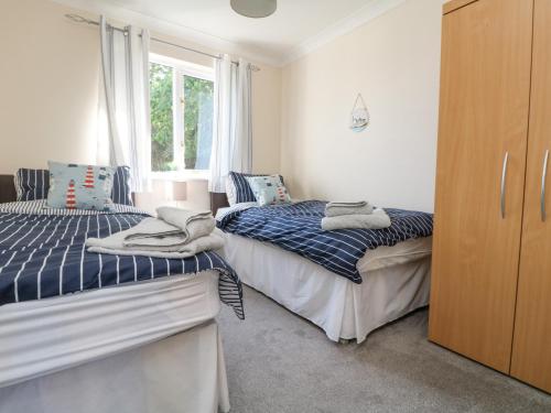 1 dormitorio con 2 camas y ventana en Owls Roost, en Falmouth