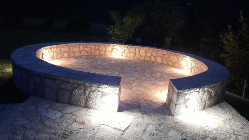a stone circle with lights on it at night at Aleksa in Cetinje