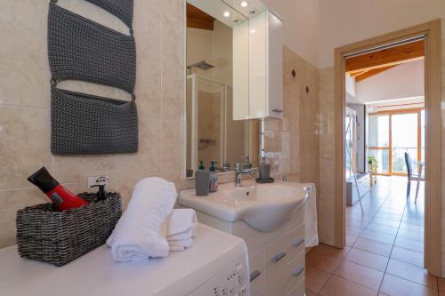 a white bathroom with a sink and a mirror at Panoramic's loft in Verbania