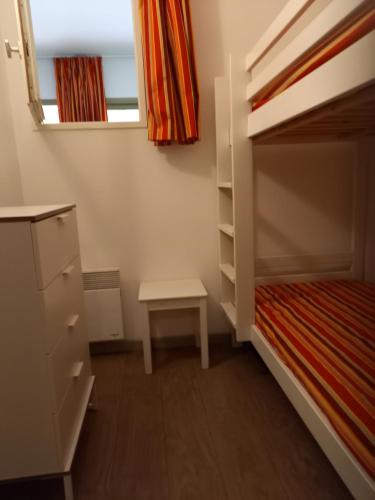 - une petite chambre avec des lits superposés et une table dans l'établissement LE VALLON DU ROY, à Sanary-sur-Mer