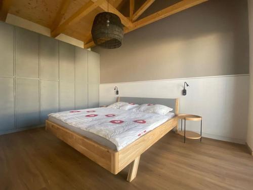 Slunečný dům s klimatizací s výhledem na Pálavu في Brod nad Dyjí: سرير كبير في غرفة مع أرضية خشبية