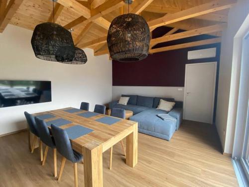 ein Wohnzimmer mit einem Tisch und einem blauen Sofa in der Unterkunft Slunečný dům s klimatizací s výhledem na Pálavu in Brod nad Dyjí