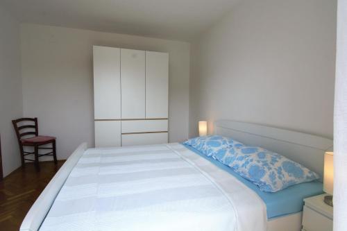um quarto com uma cama branca e uma almofada azul em Villa Vienna em Novigrad Istria