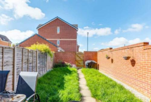 a yard with a brick fence and a brick building at Big ensuite bed room in a modern town house in Coundon