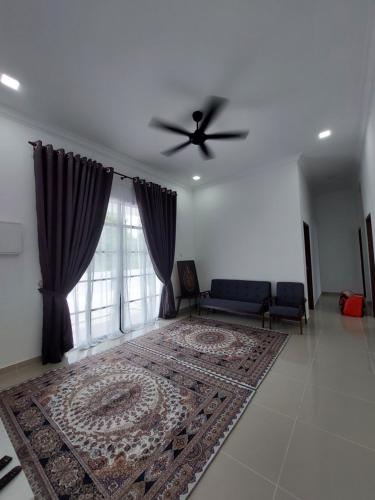 een woonkamer met een plafondventilator en een bank bij Homestay2 Tok Bali in Pasir Puteh