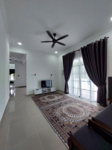 een woonkamer met een plafondventilator en een groot raam bij Homestay2 Tok Bali in Pasir Puteh