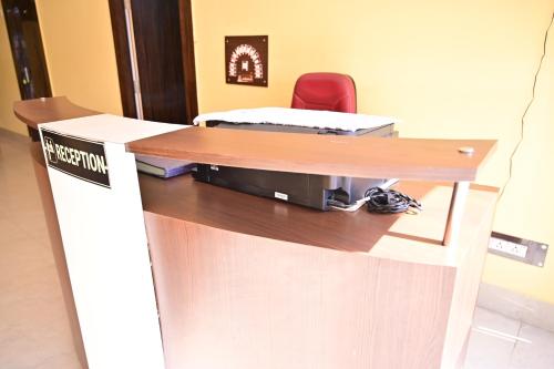 a reception desk with a laptop on top of it at Hotel Palak in Deoghar