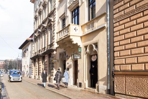 Un groupe de personnes marchant dans une rue à côté des bâtiments dans l'établissement House of Frida, à Cracovie