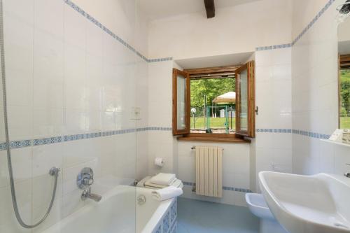 y baño con bañera, lavabo y aseo. en Villa Il Mulino, en Calbenzano