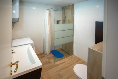 een badkamer met een douche, een wastafel en een toilet bij Izi in Split