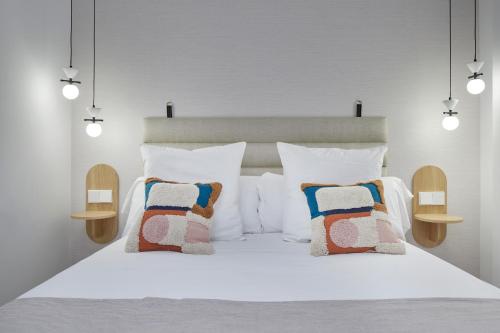 a bedroom with a white bed with two pillows at Daira Arena by FeelFree Rentals in San Sebastián