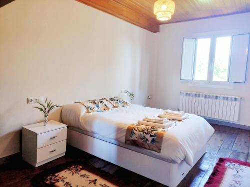 - une chambre blanche avec un lit et une fenêtre dans l'établissement Casa de Ribeira Sacra con calefacción, à Pantón