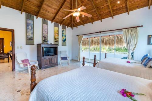 een slaapkamer met 2 bedden en een plafondventilator bij VILLA LOS ENSUENOS NEAR BEACH AND GOLF POOL JACUZZI MAiD in Punta Cana