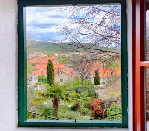 uma janela com vista para um jardim exterior em Guest house Ana em Drnis