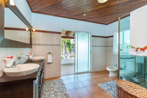 a bathroom with two sinks and a shower and a toilet at VILLA LOS ENSUENOS NEAR BEACH AND GOLF POOL JACUZZI MAiD in Punta Cana