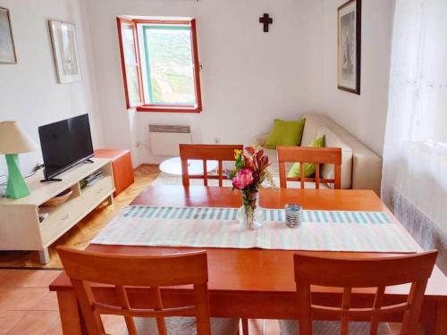 uma sala de estar com uma mesa com um vaso de flores em Guest house Ana em Drnis