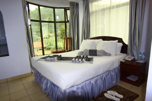a bedroom with a large bed with a window at Green Mountain Hotel in Arusha