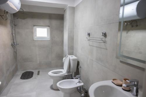 La salle de bains est pourvue de toilettes et d'un lavabo. dans l'établissement Three doors apartments, Strawberry Studio, à Tirana