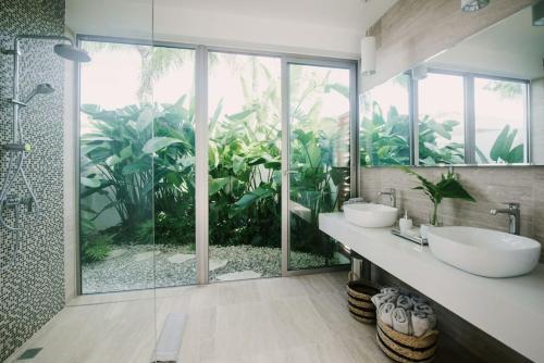 a bathroom with two sinks and a large glass window at VILLA BELLA LUNA WITH CHEF MAiD GOLF CART AND POOL in Punta Cana