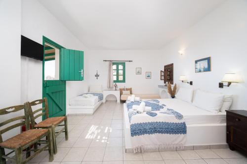 una camera con letto, tavolo e sedie di TA PLAGIA accommodation ad Anáfi