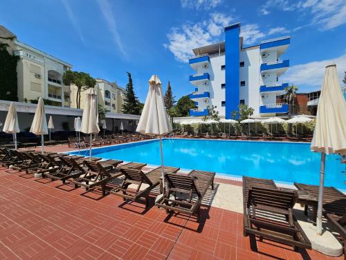 a swimming pool with chairs and umbrellas next to a building at SunBorn Hotel in Golem
