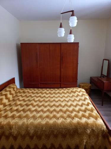 une chambre avec un lit avec un couvre-lit jaune dans l'établissement Gite l ecureuil, à Saint-Nectaire