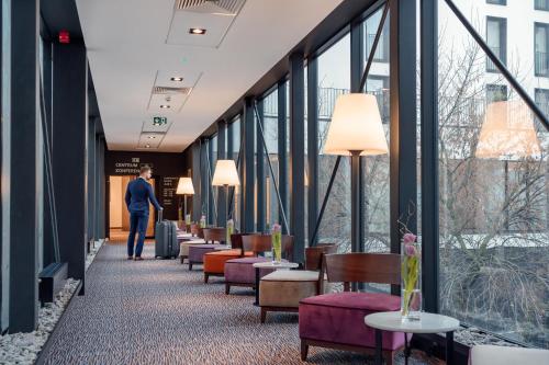 korytarz z krzesłami i stołami w budynku z oknami w obiekcie B&B HOTEL RZESZÓW CENTRUM w mieście Rzeszów