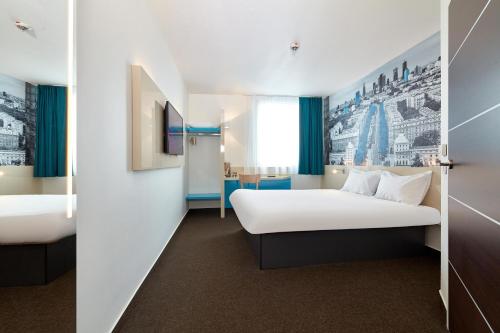 ein Hotelzimmer mit 2 Betten und einem Spiegel in der Unterkunft B&B Hotel Warszawa-Okęcie in Warschau