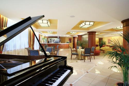 a piano in a lobby with a restaurant at Hotel Parco Delle Rose in San Giovanni Rotondo