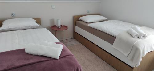 a bedroom with two beds and a red table at Veronika's House je prijeten, miren apartma v naravi, blizu mesta in Celje