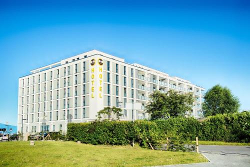 un gran edificio blanco con un letrero amarillo. en B&B Hotel Wilhelmshaven, en Wilhelmshaven