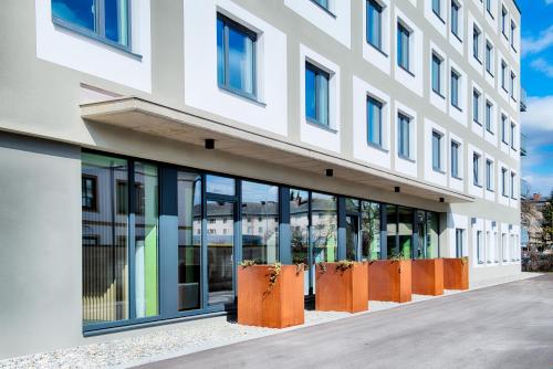um edifício de escritórios com grandes janelas e laranjas em B&B Hotel Villach em Villach