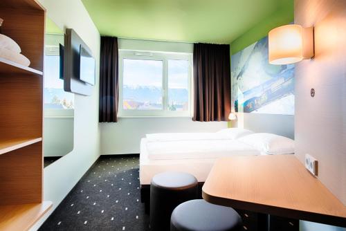 菲拉赫的住宿－B&B Hotel Villach，酒店客房设有两张床和一张桌子。